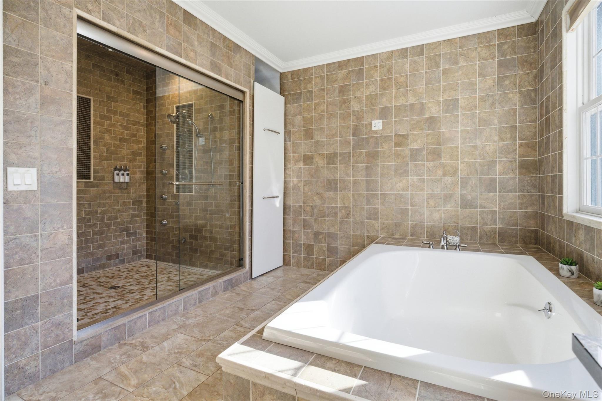 33 A Newtown Road Hampton Bays, NY 11946 - Photo 39 of 50 Full bathroom with tile walls, a garden tub, ornamental molding, and a stall shower