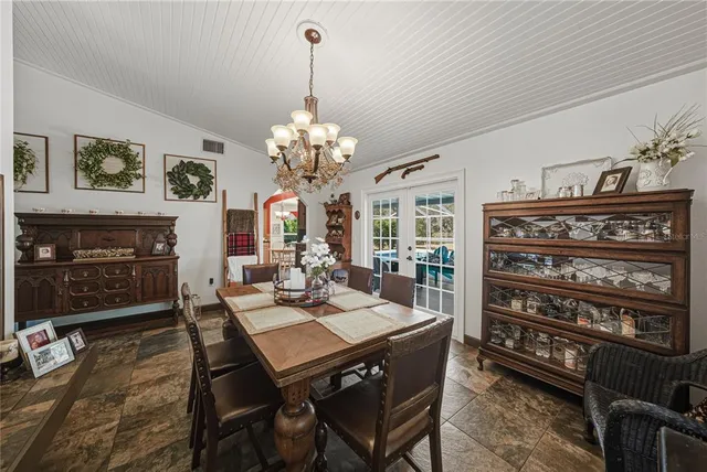 a view of a dining room with furniture a chandelier and wooden floor