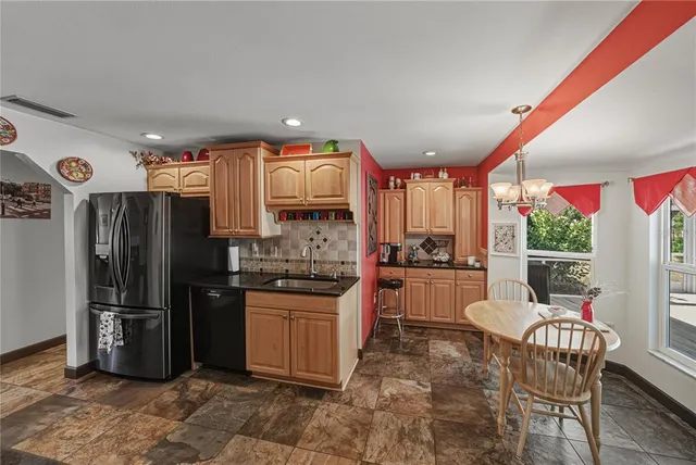a kitchen with granite countertop a refrigerator and a stove top oven