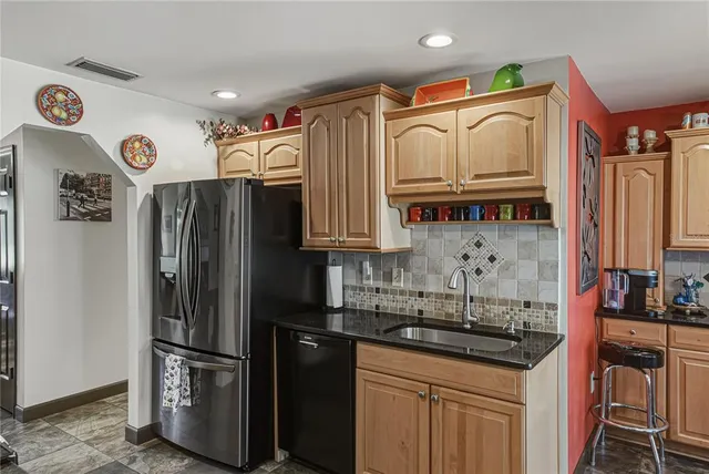 a kitchen with stainless steel appliances granite countertop a refrigerator and a sink