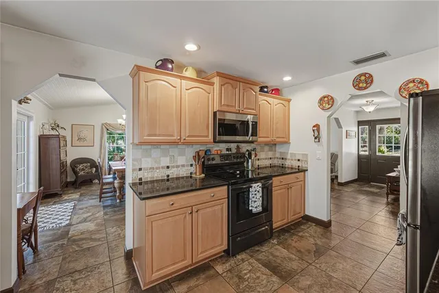 a kitchen with granite countertop a sink and white cabinets