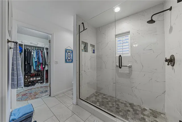 a bathroom with a granite countertop shower a sink and a mirror