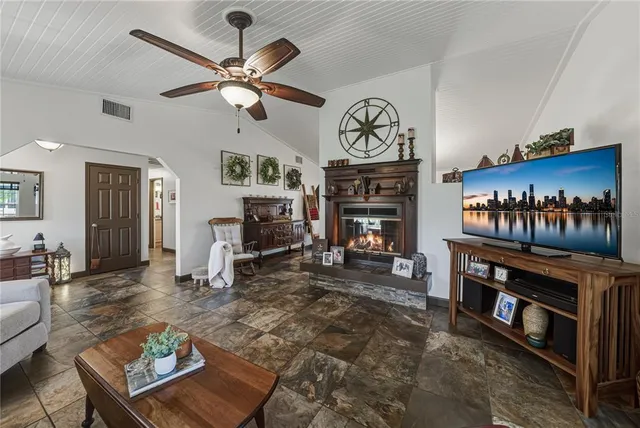 a living room with furniture a fireplace and a flat screen tv