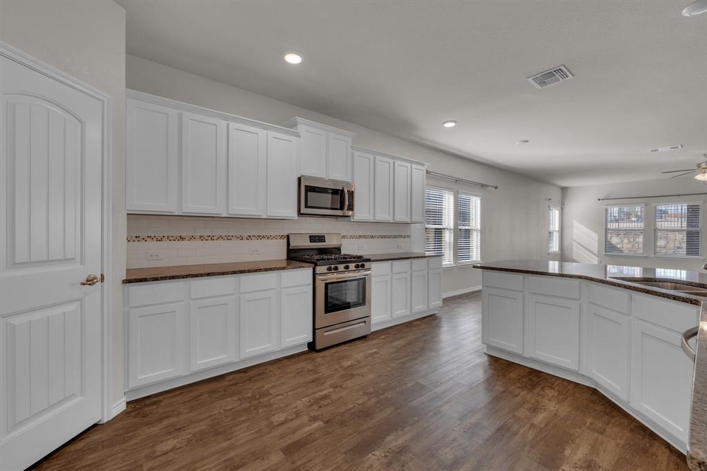 610 Bassett Hall Road Fate, TX 75189 - Photo 8 of 28 Kitchen featuring white cabinetry, tasteful backsplash, appliances with stainless steel finishes, dark hardwood / wood-style flooring, and ceiling fan