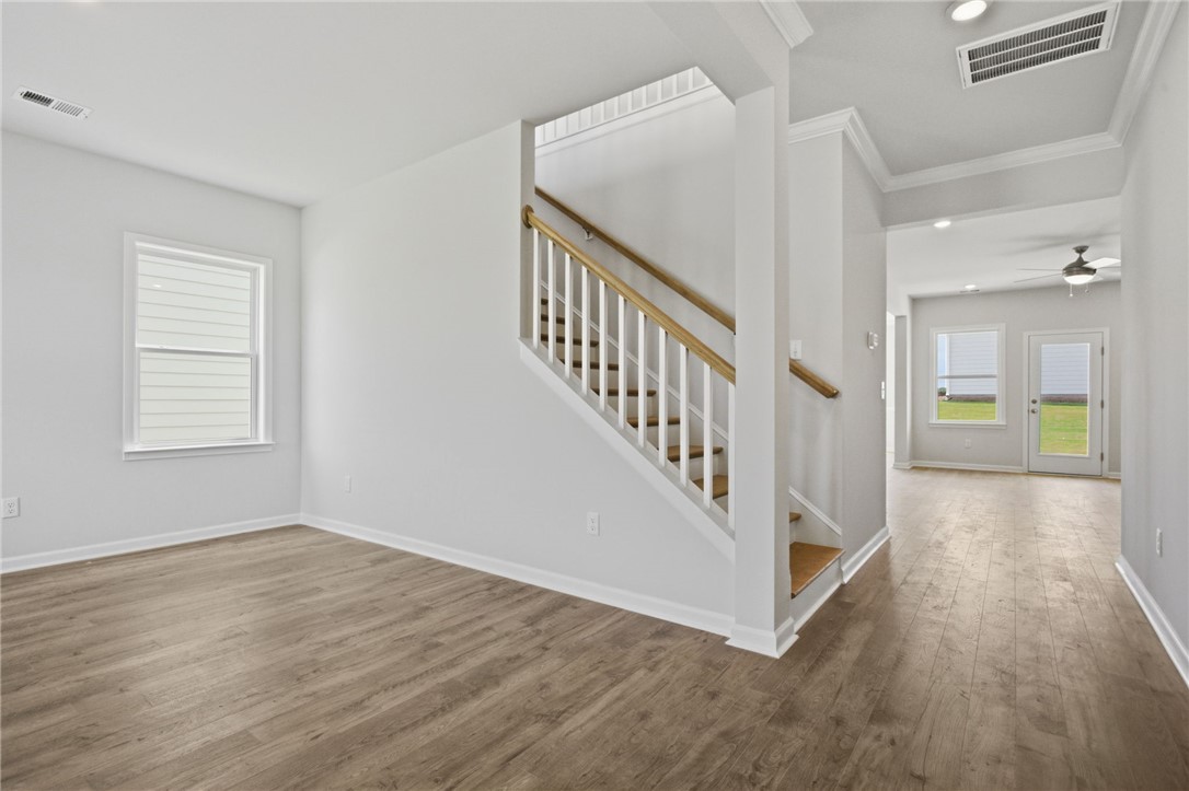 557 Hydrangea Street, Unit LOT 46 Seneca, SC 29678 - Photo 4 of 37 A well-lit interior features warm wood flooring and a classic staircase, inviting exploration.