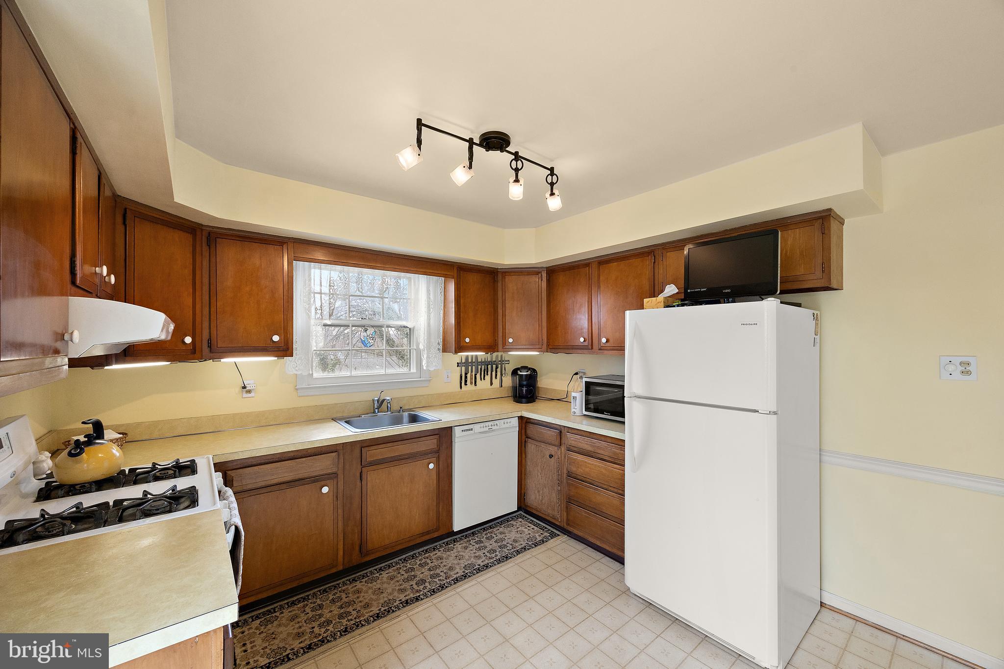 509 Holly Knoll Road Hockessin, DE 19707 - Photo 11 of 34 a kitchen with a sink a refrigerator and cabinets