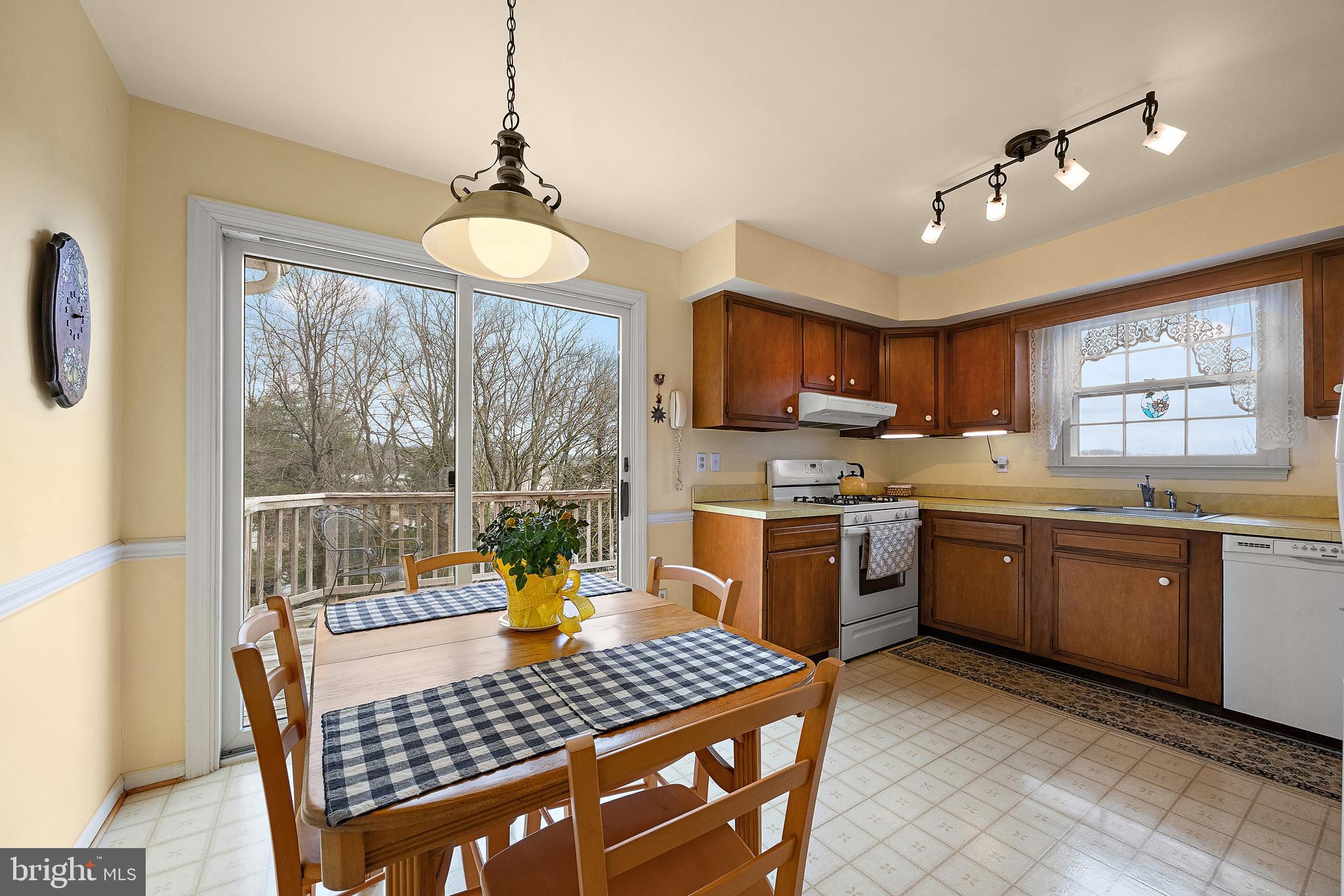 509 Holly Knoll Road Hockessin, DE 19707 - Photo 8 of 34 a kitchen with a stove a sink a microwave and dining table
