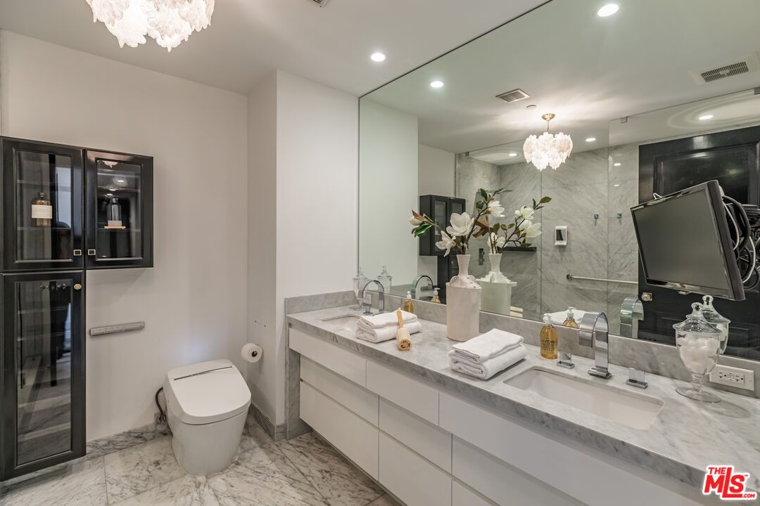 10727 Wilshire Boulevard, Unit 1702 Los Angeles, CA 90024 - Photo 17 of 43 a bathroom with a toilet sink and mirror