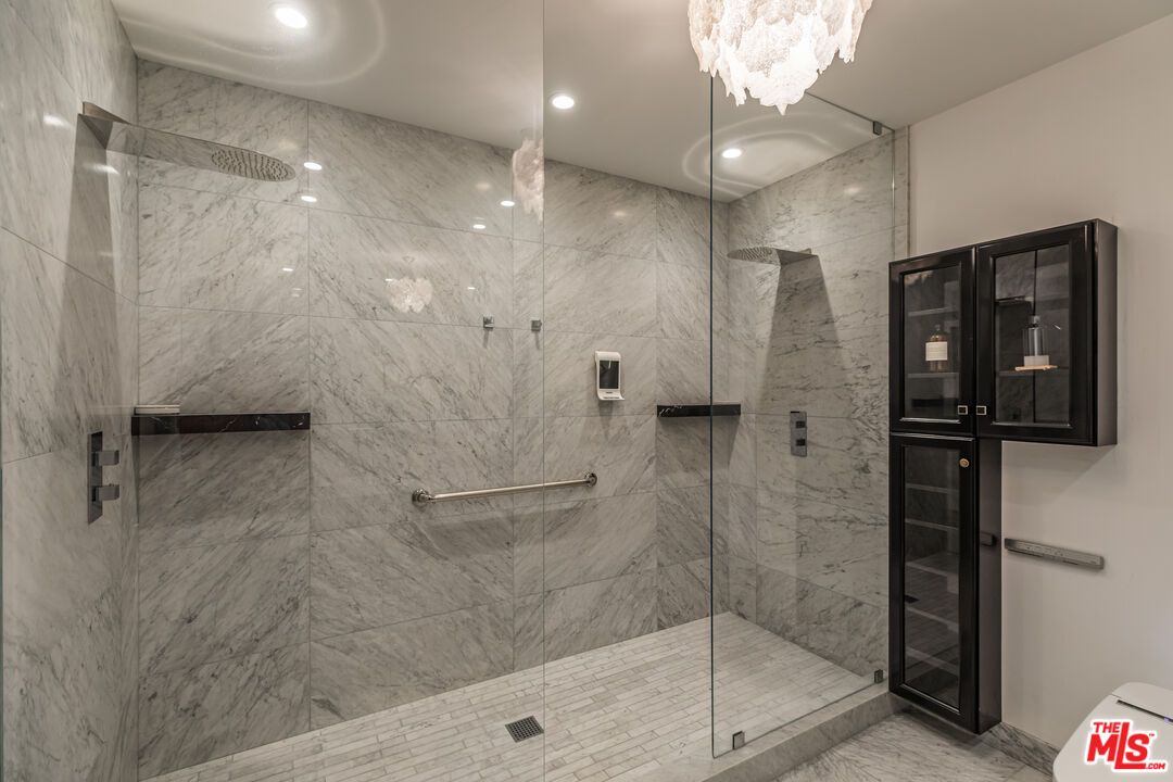 10727 Wilshire Boulevard, Unit 1702 Los Angeles, CA 90024 - Photo 18 of 43 a bathroom with a shower and a glass door
