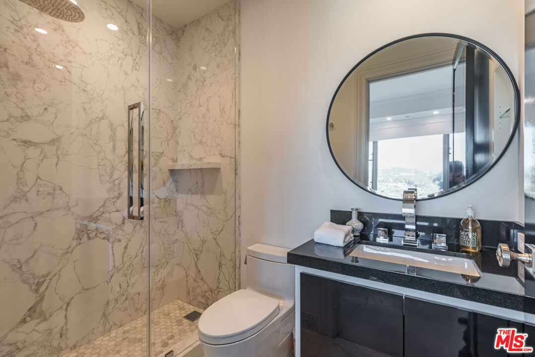10727 Wilshire Boulevard, Unit 1702 Los Angeles, CA 90024 - Photo 23 of 43 a bathroom with a sink a toilet and a mirror
