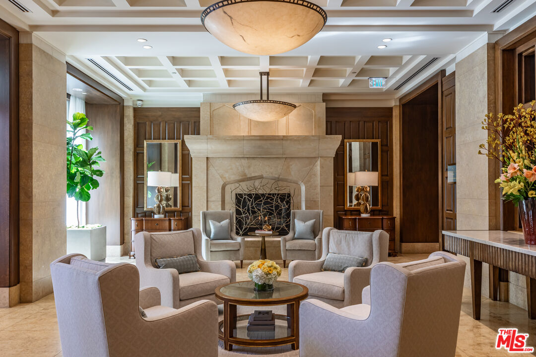 10727 Wilshire Boulevard, Unit 1702 Los Angeles, CA 90024 - Photo 25 of 43 a living room with furniture a fireplace and a chandelier