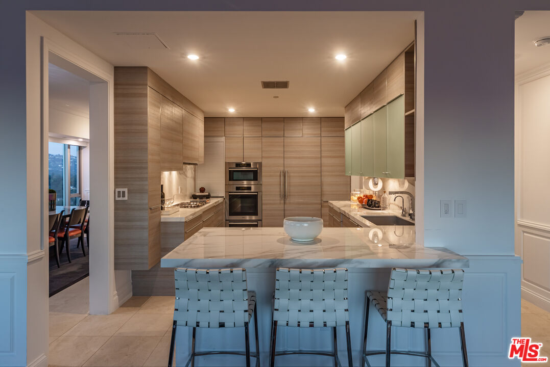 10727 Wilshire Boulevard, Unit 1702 Los Angeles, CA 90024 - Photo 34 of 43 a kitchen with a table and chairs in it