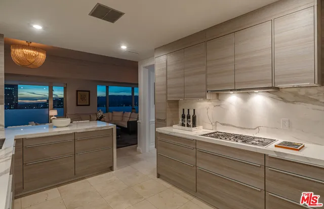 a living room with furniture a flat screen tv and kitchen view