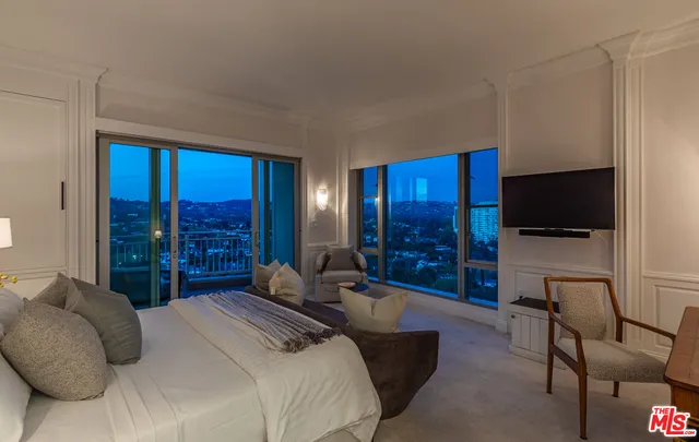 a bedroom with furniture and a large window