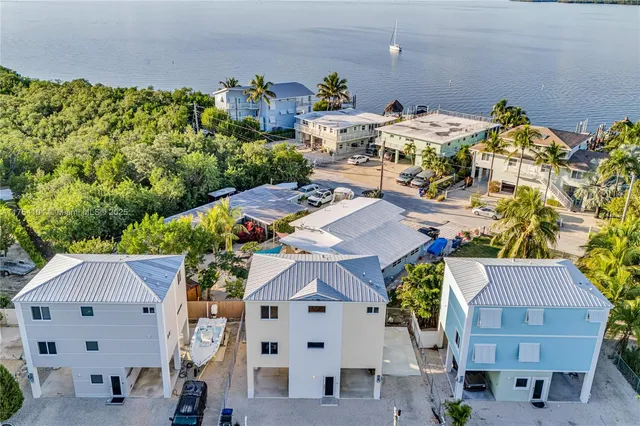 an aerial view of a house with a yard and seating space