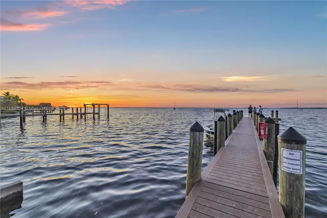 a kitchen with a refrigerator a sink and dishwasher with wooden floors