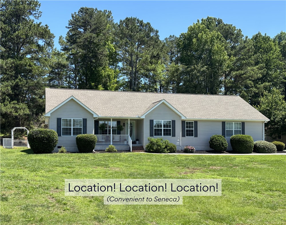 848 Perkins Creek Road Seneca, SC 29678 - Photo 1 of 26 A welcoming front porch with white railings graces this traditional home, set against a backdrop of mature trees.