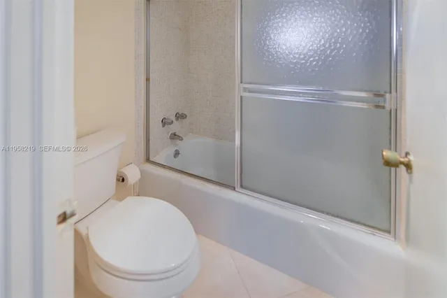 a bathroom with a granite countertop toilet and a shower
