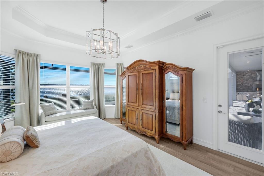 14630 Blue Bay Circle Fort Myers, FL 33913 - Photo 16 of 43 a spacious bedroom with a bed and a chandelier