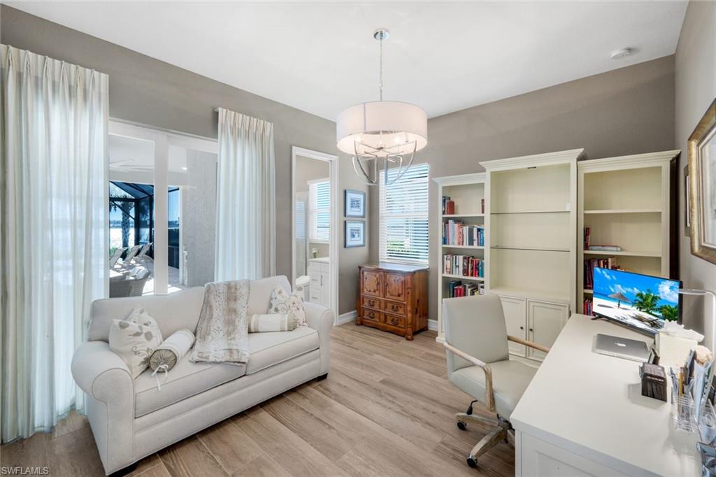 14630 Blue Bay Circle Fort Myers, FL 33913 - Photo 20 of 43 a living room with furniture a chandelier and a flat screen tv