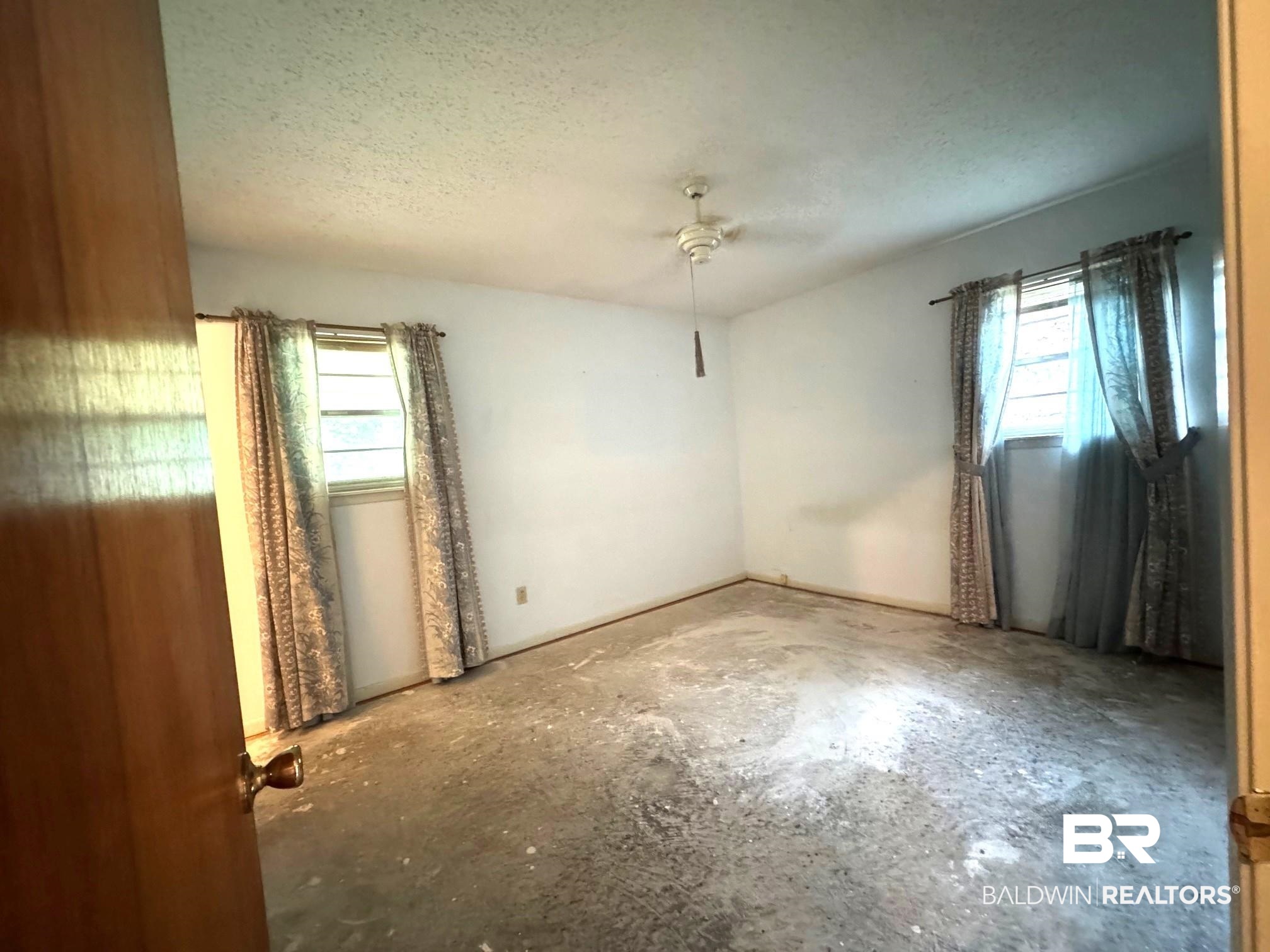 5198 Lancelot Drive Mobile, AL 36619 - Photo 15 of 30 Empty room featuring a ceiling fan, a textured ceiling, and unfinished concrete flooring