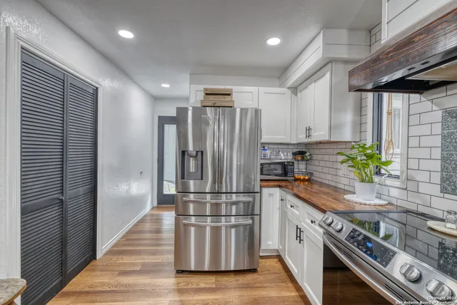 a kitchen with granite countertop stainless steel appliances a counter top space cabinets and a window