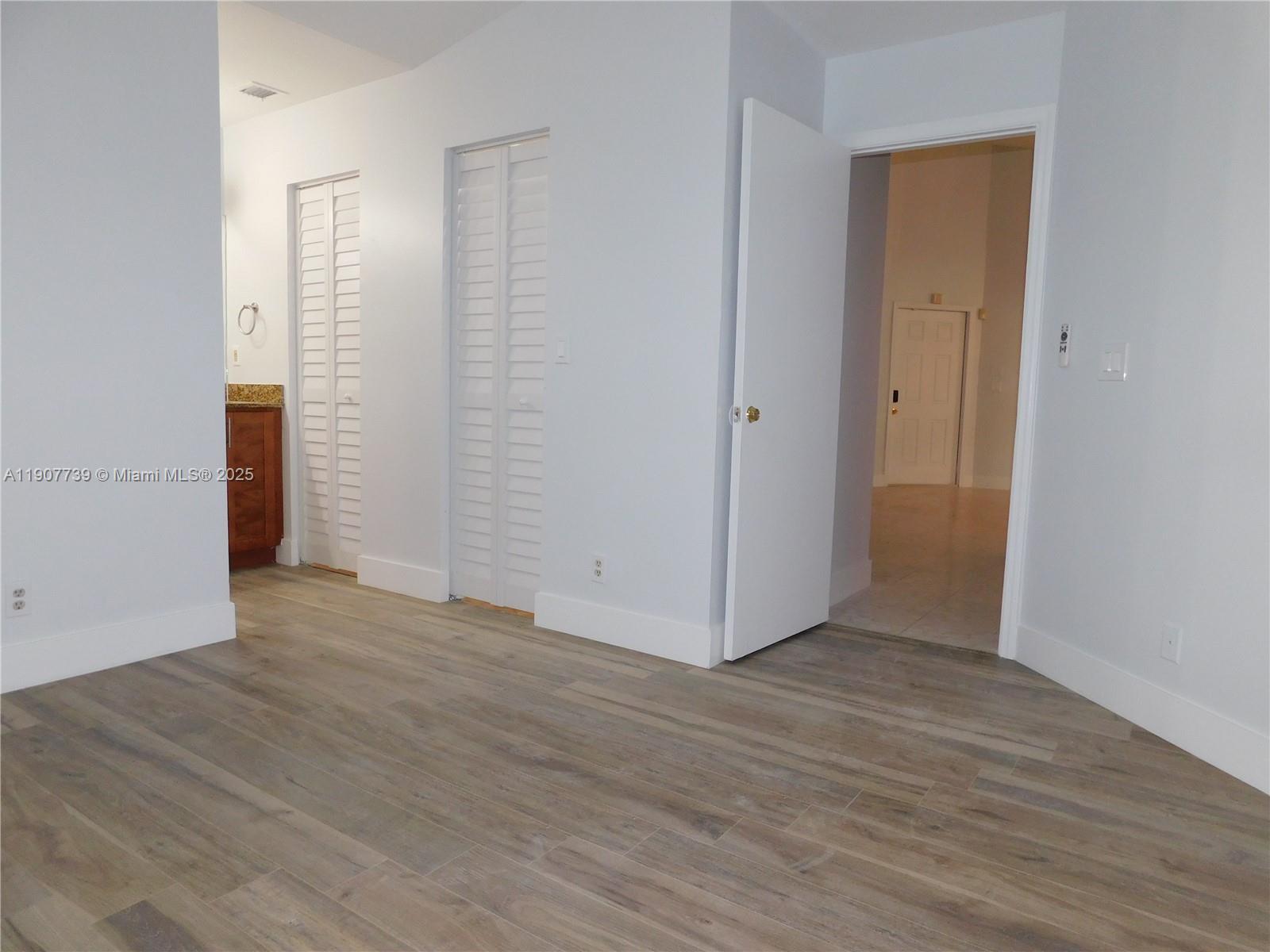 2851 River Run Circle West, Unit 2851 Miramar, FL 33025 - Photo 12 of 33 an empty room with wooden floor & closet area