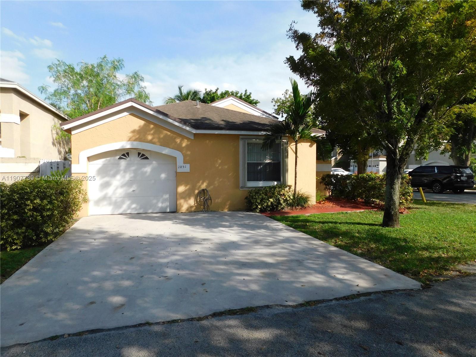 2851 River Run Circle West, Unit 2851 Miramar, FL 33025 - Photo 13 of 33 a front view of a house with a yard and a garage
