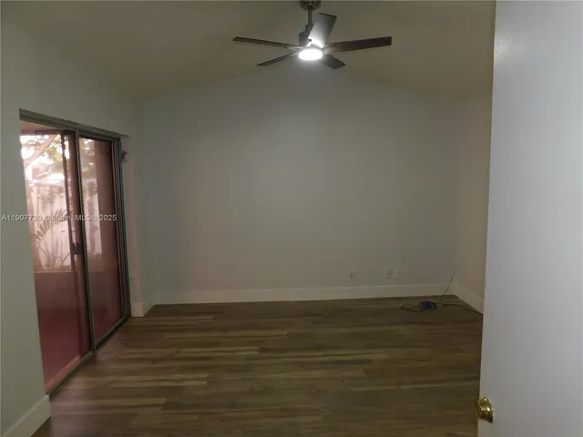 a view of an empty room with wooden floor and closet