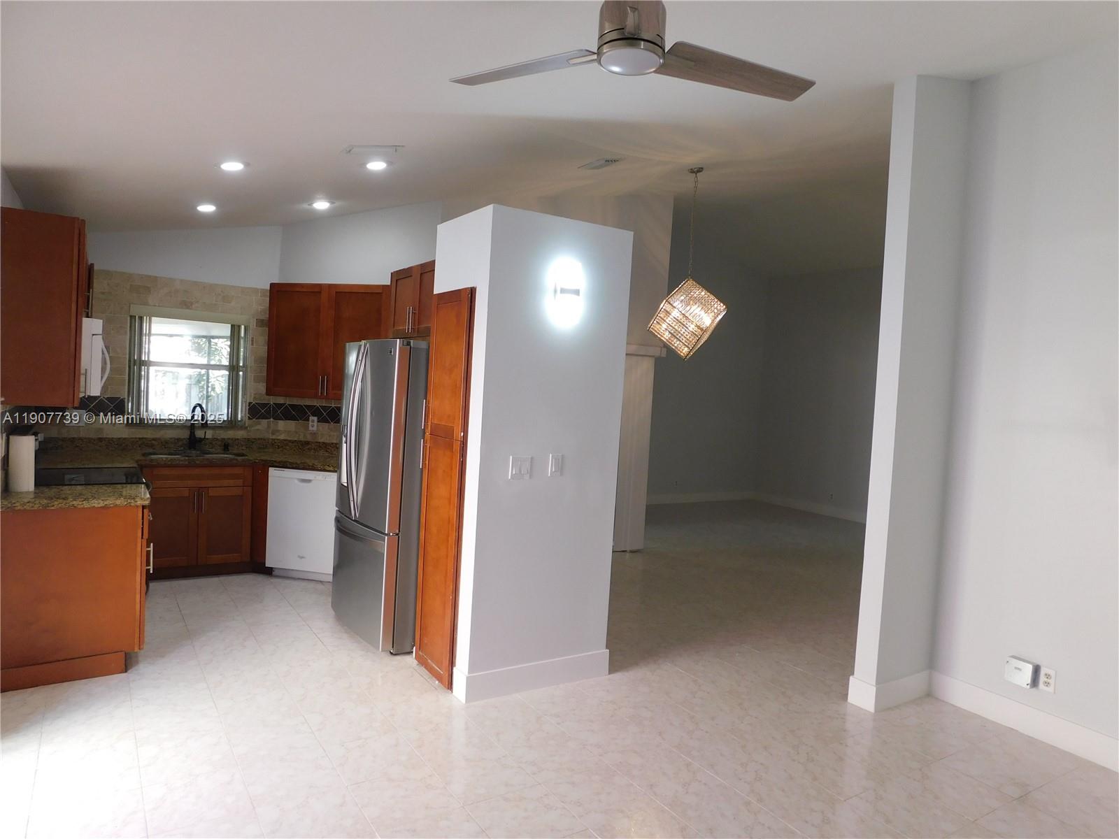 2851 River Run Circle West, Unit 2851 Miramar, FL 33025 - Photo 7 of 33 a view of a kitchen with refrigerator and wooden floor