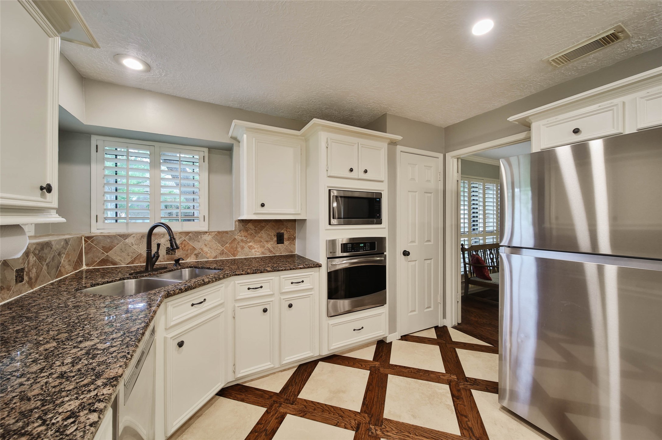 17007 Windrow Drive Spring, TX 77379 - Photo 15 of 46 a kitchen with granite countertop a refrigerator stove a sink and dishwasher with wooden floor