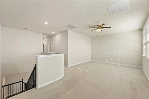 a view of an empty room with a ceiling fan