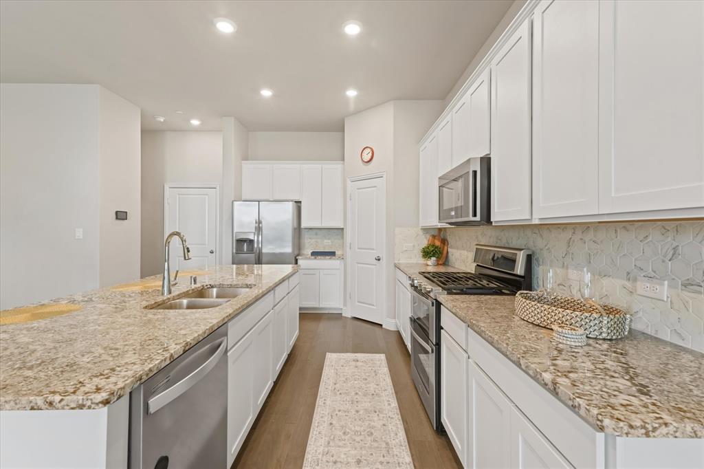7401 Sunset Boulevard Rowlett, TX 75088 - Photo 15 of 35 a large kitchen with stainless steel appliances granite countertop a sink stove and cabinets