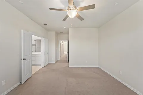 an empty room with chandelier fan and closet area