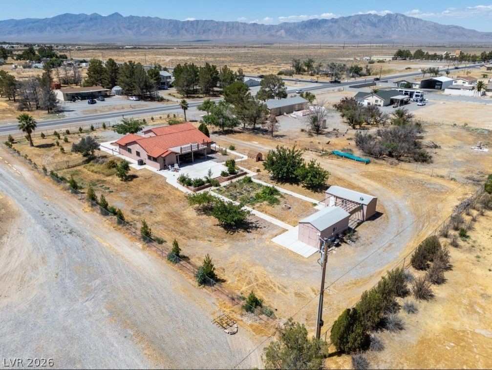 1220 East Gamebird Road Pahrump, NV 89048 - Photo 45 of 49 An aerial perspective reveals a charming property nestled amidst arid landscapes, boasting mountain views and convenient road access.