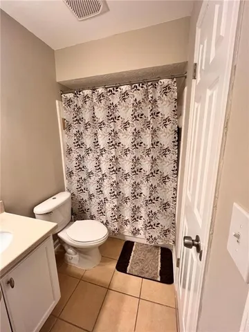 a bathroom with a toilet and a shower curtain