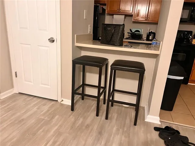 a kitchen with a sink a refrigerator and wooden floor