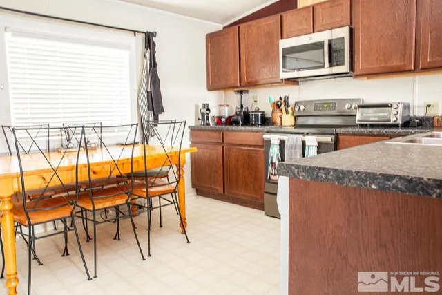 a kitchen with stainless steel appliances granite countertop a stove top oven a sink and a microwave