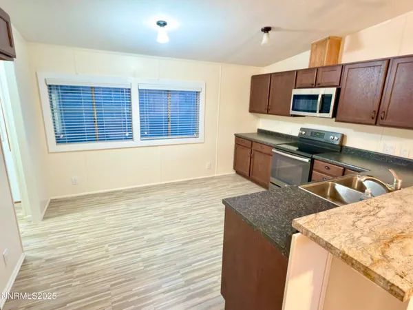 a kitchen with stainless steel appliances granite countertop a sink stove and microwave