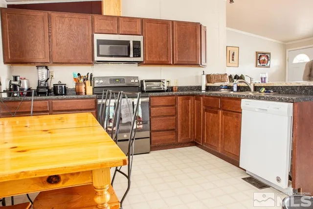 a kitchen with stainless steel appliances granite countertop a stove a sink and a microwave