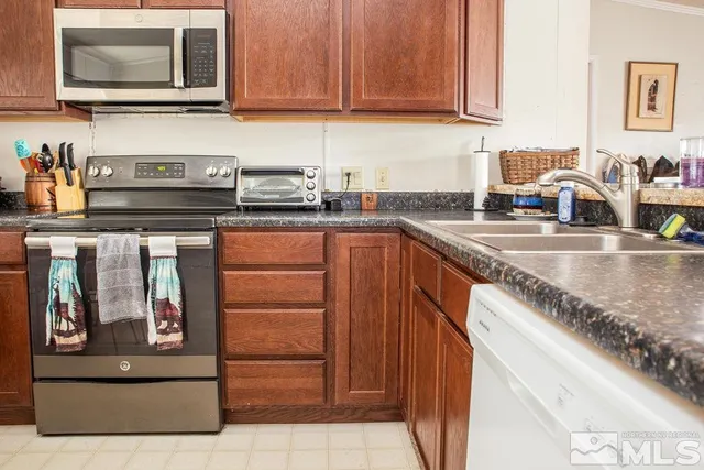 a kitchen with stainless steel appliances granite countertop a sink and a microwave