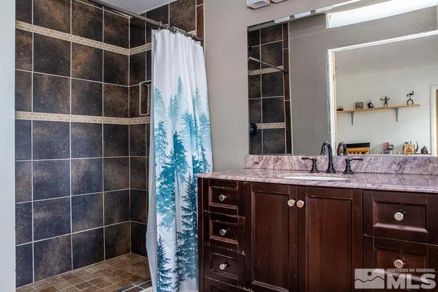 a bathroom with a granite countertop toilet a sink and a mirror