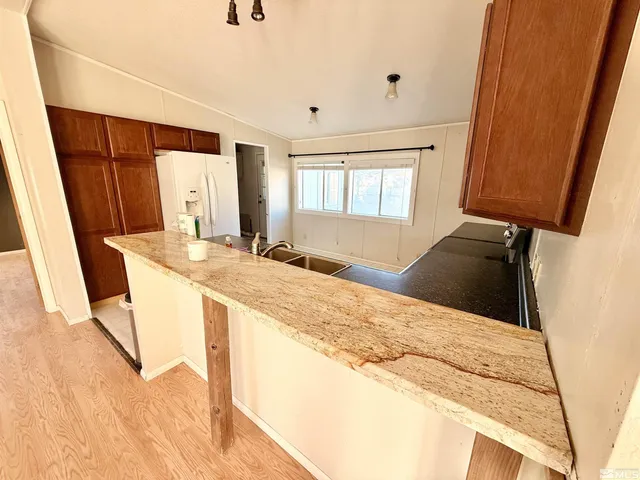 a kitchen with stainless steel appliances kitchen island granite countertop a refrigerator a stove top oven with a sink and dishwasher
