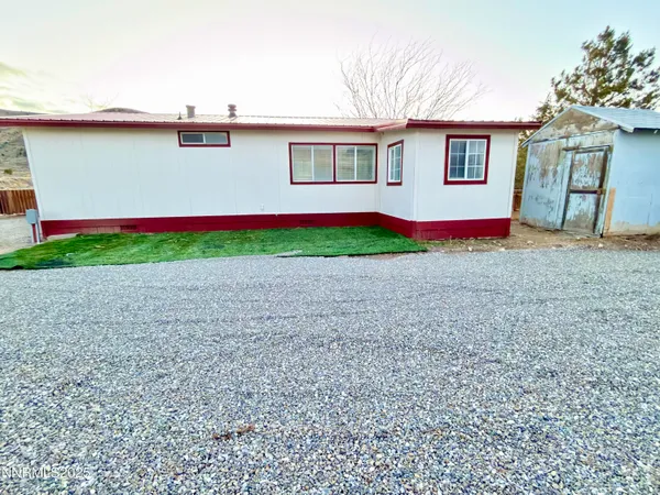 a view of a house with a yard and a large tree