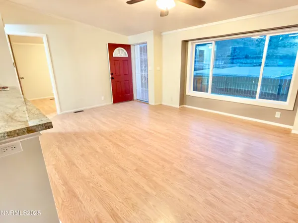 a view of empty room with wooden floor and window