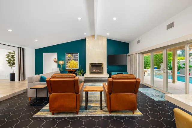 a living room with fireplace furniture and a large window