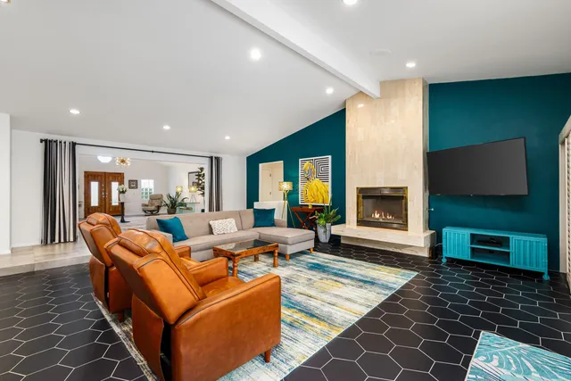 a living room with furniture a flat screen tv and a fireplace