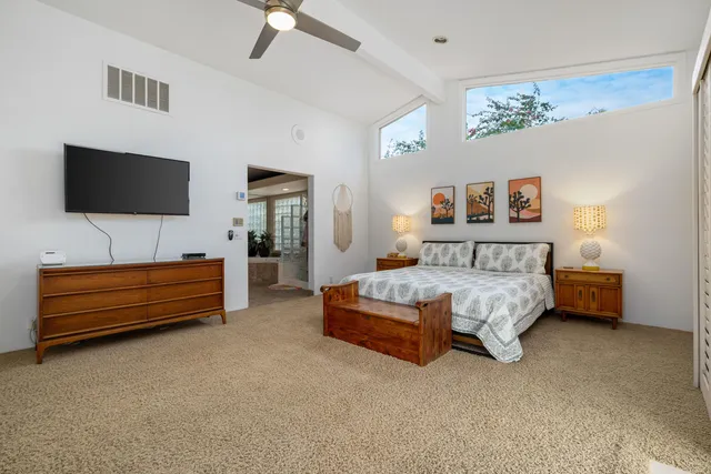a bedroom with bed and a flat screen tv