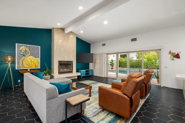 a living room with fireplace furniture and a large window