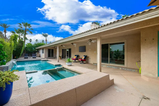 a view of a house with backyard and sitting area